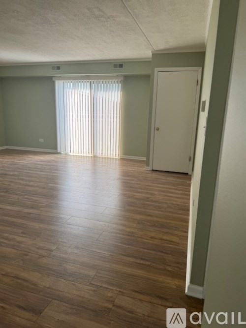 A room with wooden flooring and a white door.