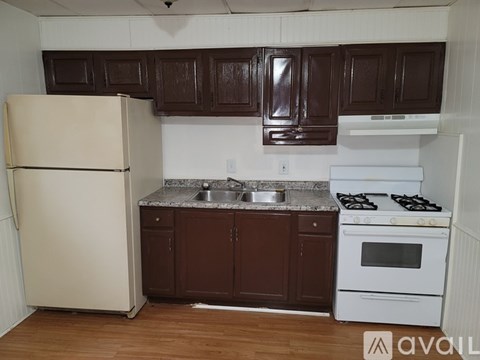A kitchen with brown cabinets and a white stove.