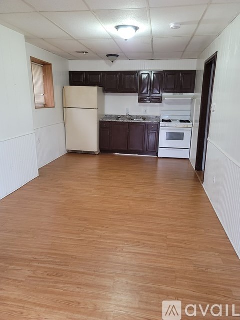 A kitchen with wooden floors and white walls.