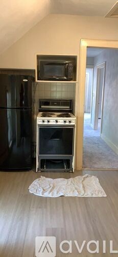 A kitchen with a black fridge and a microwave above it.