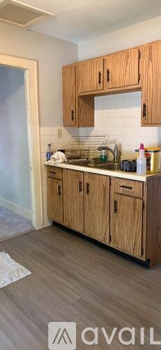A kitchen with wooden cabinets and a white tile backsplash.