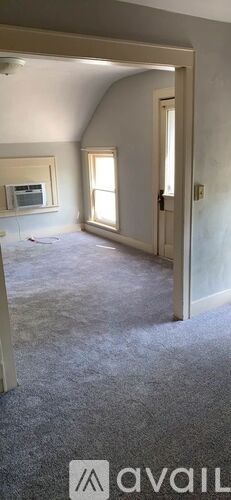A room with a carpeted floor and a doorway leading to another room.