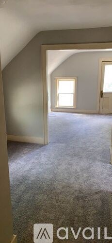 A room with a carpeted floor and a window.