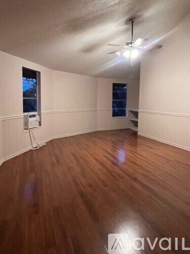 A room with wooden flooring and a ceiling fan.