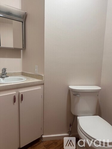 A white toilet sits next to a sink in a small bathroom.