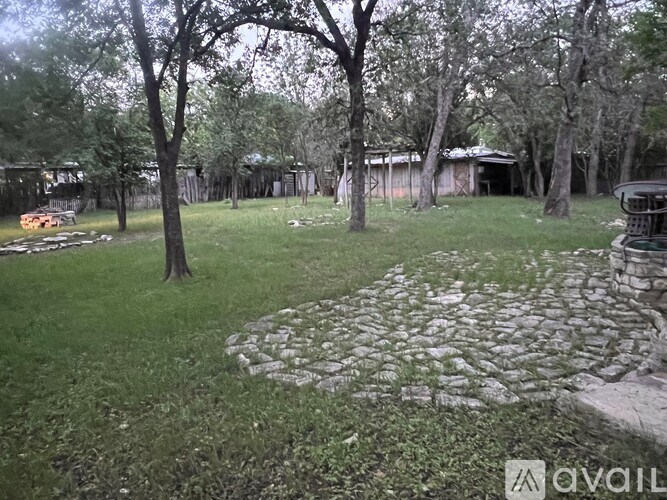 A stone pathway leads through a grassy area with trees.
