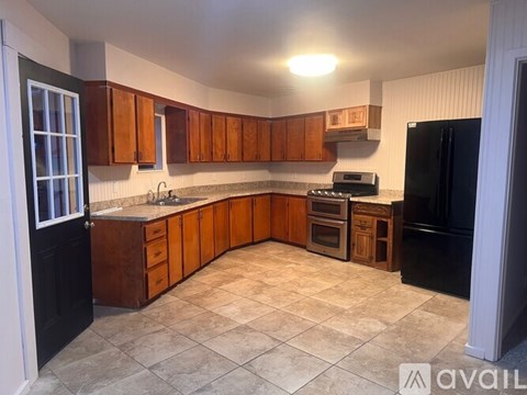 A kitchen with black appliances and wooden cabinets.