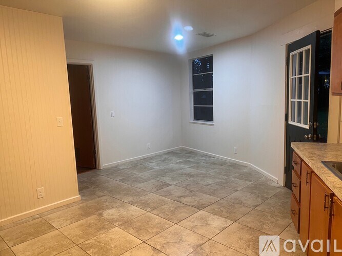 A room with tiled flooring and a window with blinds.