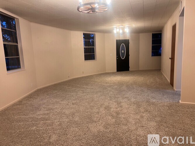 A room with a grey carpet and a black door with a white circle and star on it.