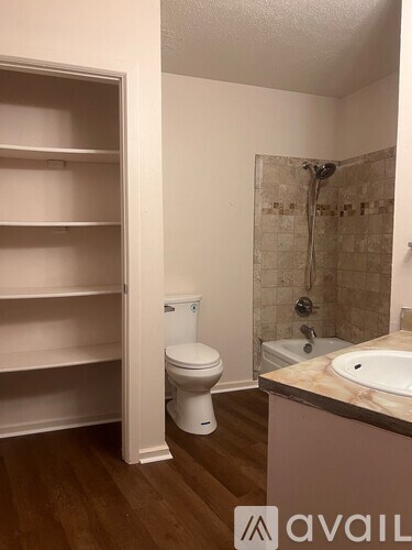 A bathroom with a toilet, sink, and shower.