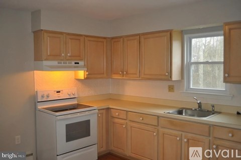 A kitchen with wooden cabinets and a white stove.