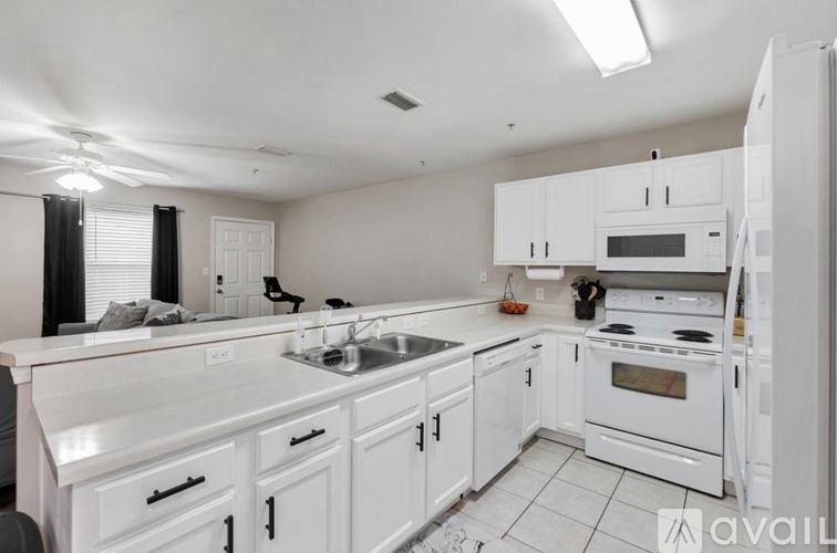 A kitchen with white cabinets and appliances.