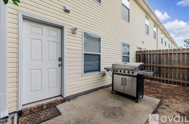 A house with a white door and a BBQ grill in front.
