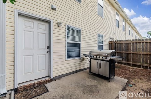 A house with a white door and a BBQ grill in front.
