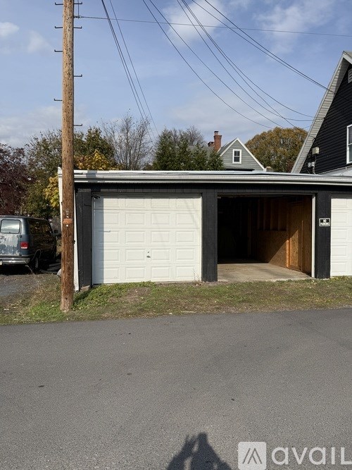 A car is parked in front of a garage.