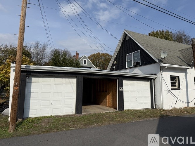 A two-car garage is attached to a white house.