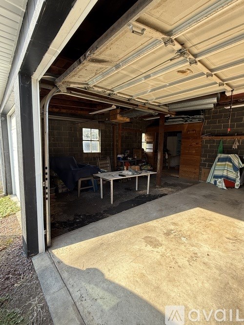 A patio area with a table and chairs under a roof.