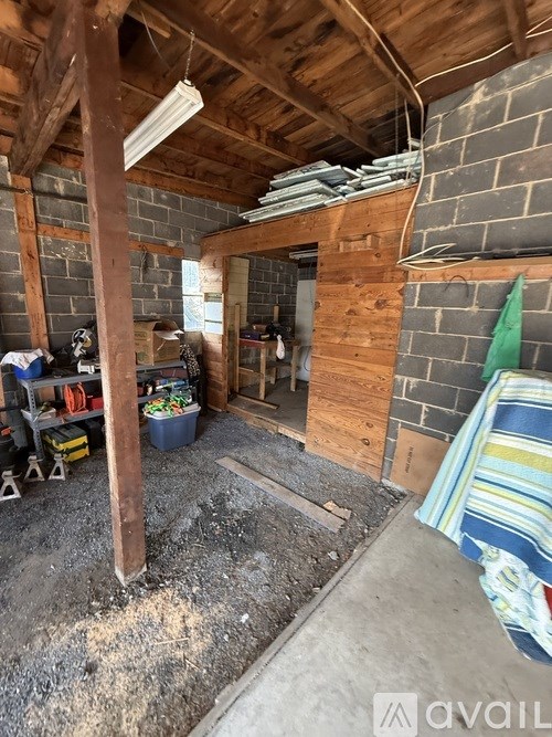 A room under construction with exposed wooden beams and brick walls.