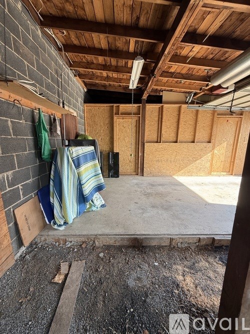 A room under construction with wooden panels on the walls and a striped towel hanging on the wall.