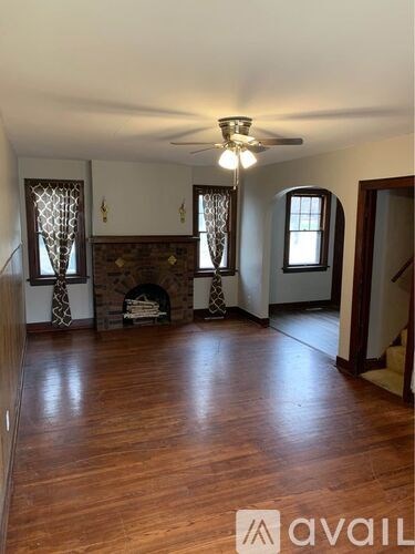 A living room with a fireplace and wooden floors.