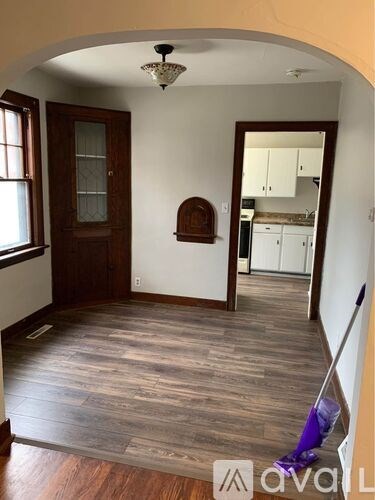 A room with wooden floors and a mop in it.