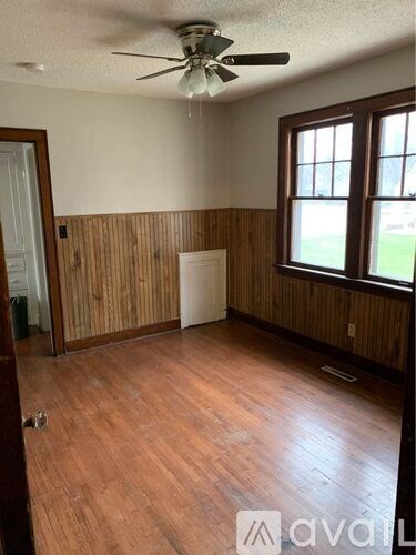A room with wood paneling and a ceiling fan.