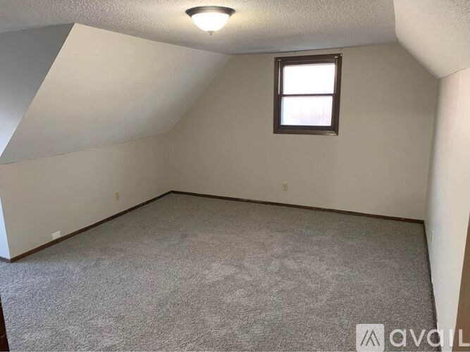A room with a carpeted floor and a window.