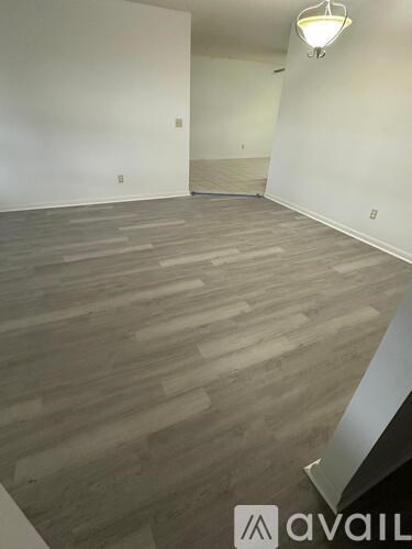 A room with wooden flooring and a light fixture on the wall.