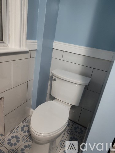 A white toilet in a bathroom with blue walls.