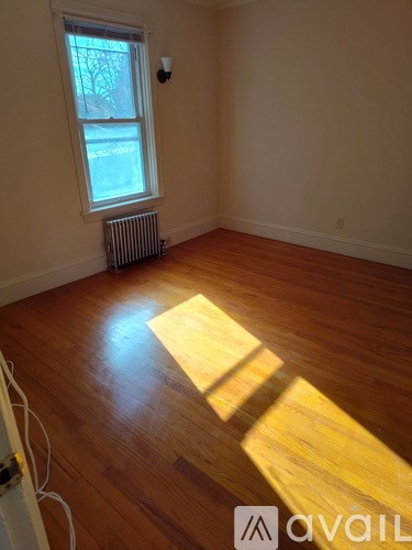 A black shower head mounted on a white tiled wall.