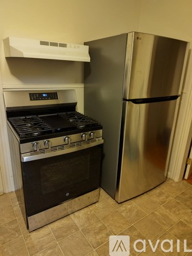 A stainless steel refrigerator and oven in a kitchen.