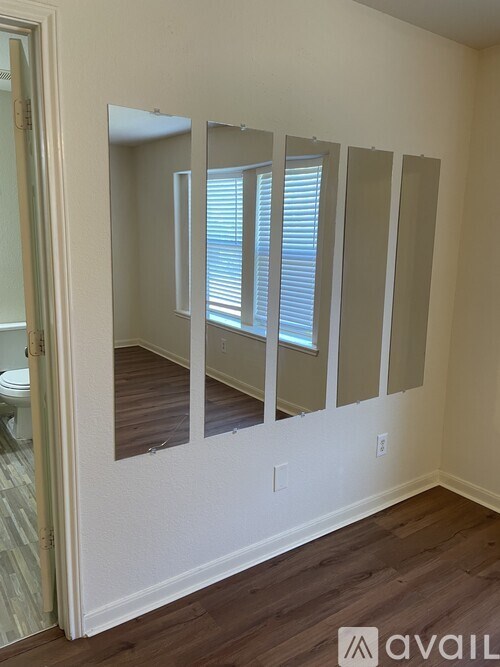 A room with a mirror and a toilet in it.