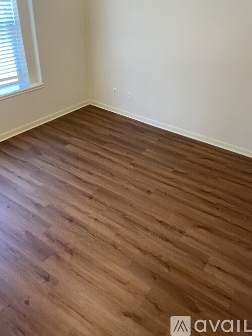 A room with wooden flooring and a window.