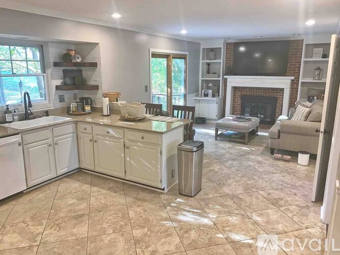 A kitchen with a white tile floor and a fireplace.