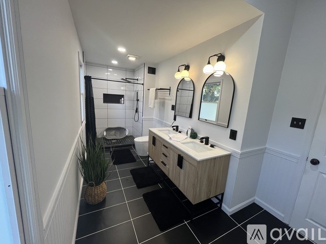 A bathroom with a white sink and black tiles.