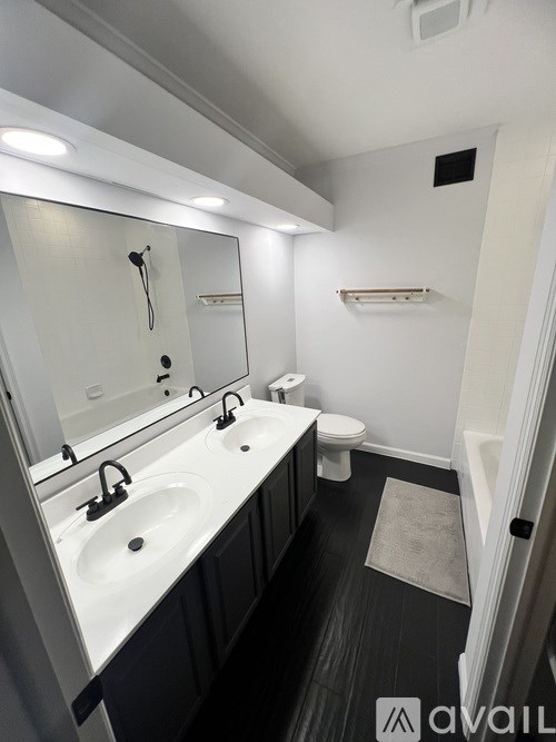 A bathroom with a sink, toilet, and mirror.