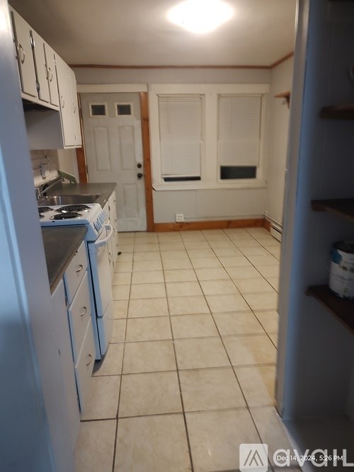 A kitchen with white cabinets and a blue refrigerator.
