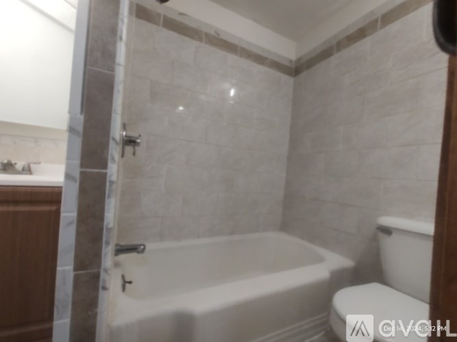 A bathroom with a white tub and toilet.