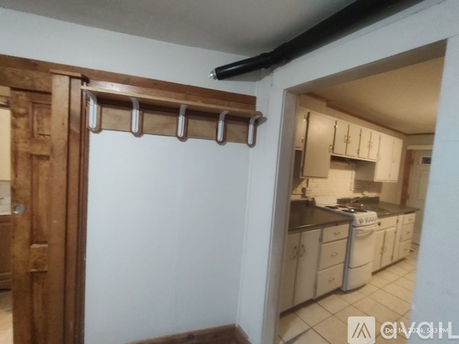 A kitchen with white cabinets and a white stove.