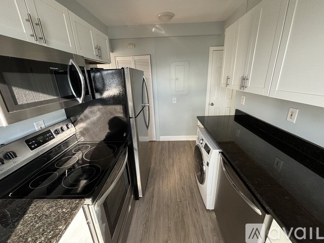 A kitchen with a black stove top oven and a black refrigerator.