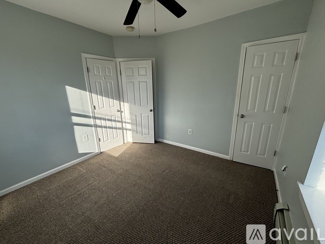 A room with two doors and a ceiling fan.