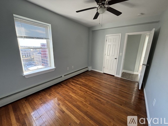 A room with a ceiling fan and wooden flooring.