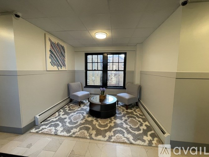 A living room with a rug, a coffee table, and a window.
