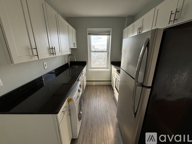 A kitchen with black countertops and white cabinets.