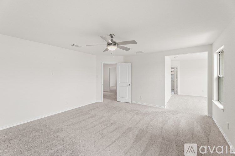 A spacious room with a ceiling fan and carpeted floor.