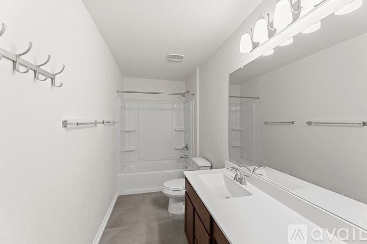 A white bathroom with a toilet, sink, and mirror.