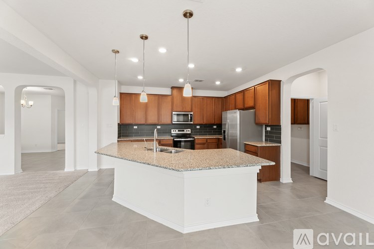 A kitchen with a granite countertop and wooden cabinets.