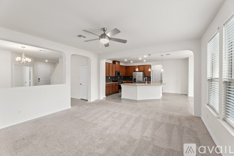 A spacious living room with a kitchen in the background.