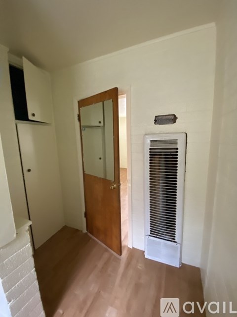A hallway with a wooden door and a white wall.