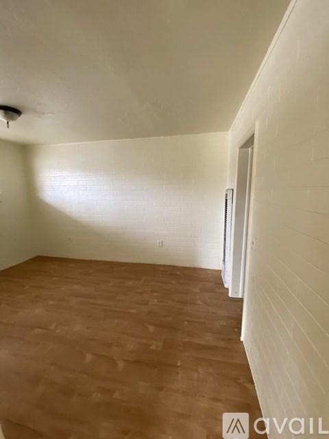 A room with wooden flooring and white walls.